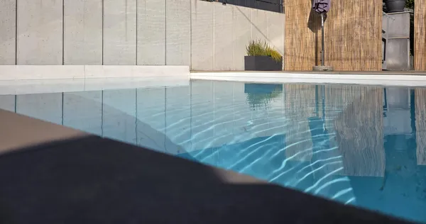 Poolbereich mit Sichtschutzwand und Umrandung gestaltet