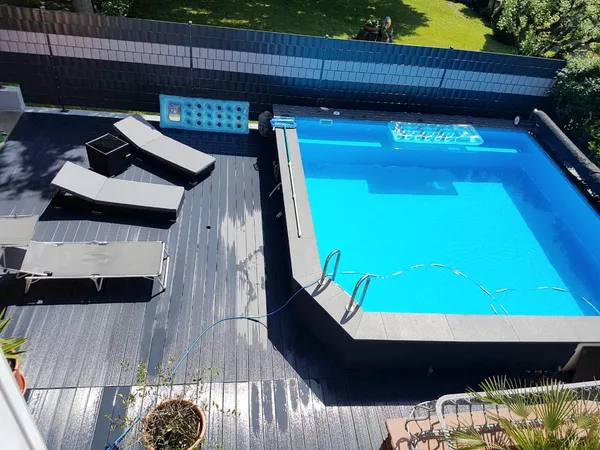 Pool mit Terrassendeck und Sichtschutz integriert