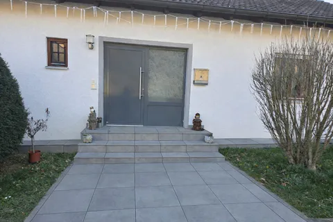Hauseingang mit großformatigen Platten und Stufen